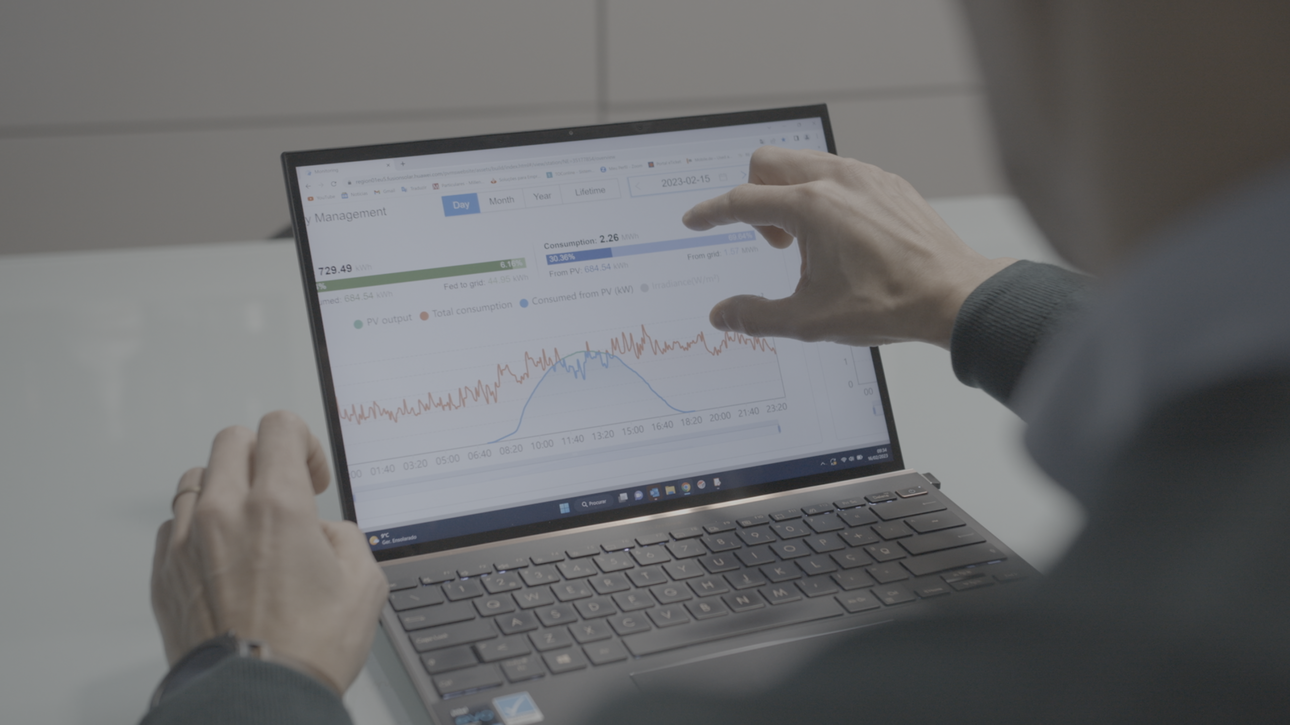 Person reviewing reports on a laptop in an office setting.